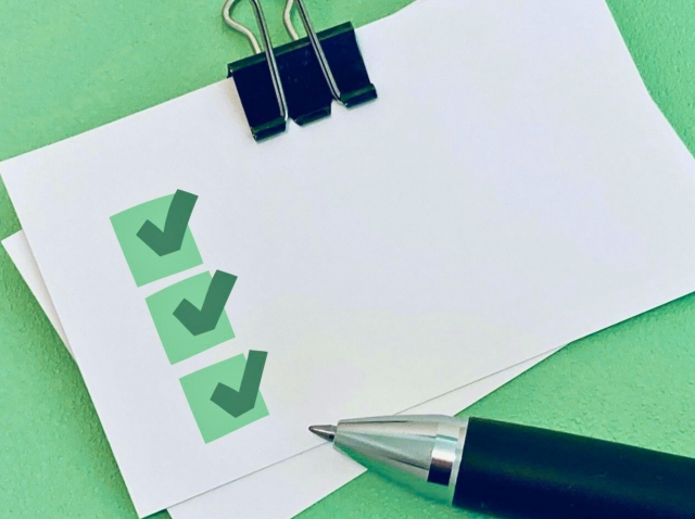 紙に書かれたチェックリストとペン