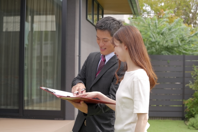 不動産会社のスタッフと話す女性